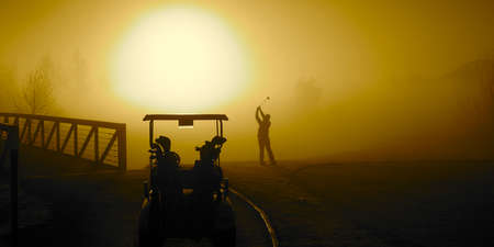 Golfer in the Golden Sunrise fog on a misty morning with a golf cartの写真素材