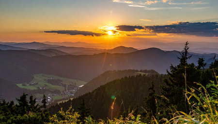 The sun dips below the horizon, casting a warm, golden light across endless layers of rolling mountain hills. A moment of serene beauty and tranquility, perfect for inspiring thoughts of adventure, peace, and new beginnings.の素材