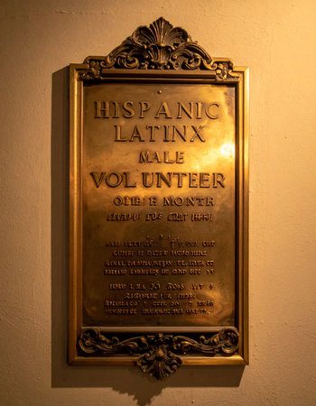 A warm light illuminates a vintage bronze plaque, recognizing the dedicated service of a Hispanic and Latinx male volunteer. This award symbolizes honor, community contribution, and a legacy of selfless work.の素材