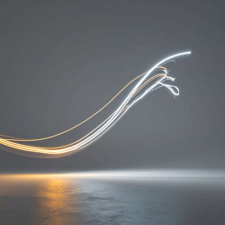 A luminous streak of golden and white light carves a graceful arc through a minimalist space. This long-exposure capture visualizes the concepts of speed, data flow, and futuristic innovation, creating a dynamic and elegant representation of energy in motion.の素材