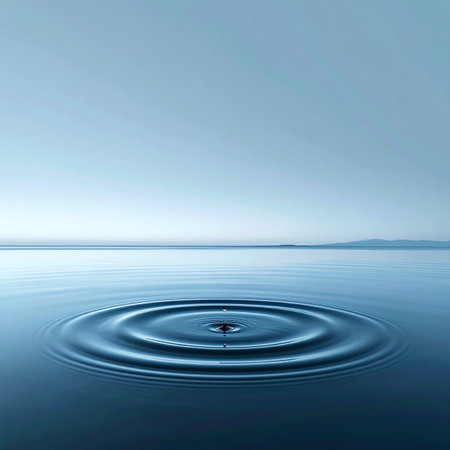 A single, perfect drop lands on a tranquil blue surface, sending out concentric ripples that disturb the stillness. This minimalist image captures the profound concept of the ripple effect, symbolizing impact, influence, and the start of something new from a single action. It evokes a sense of calm, clarity, and meditative focus.の素材