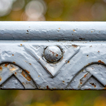 A close-up shot captures the intricate details of an old, weathered wrought iron railing.の素材