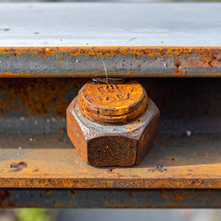 A close-up view reveals the textured surface of a heavily rusted nut and bolt, a testament to time and the elements.の素材