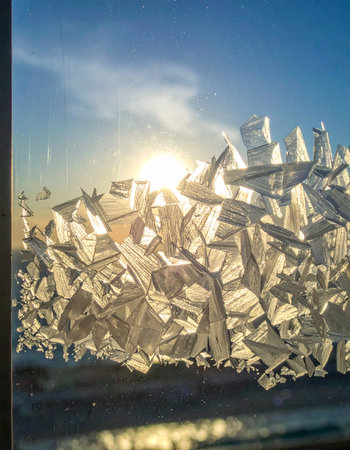 The morning sun bursts through a fractured pane of glass, scattering light into a thousand brilliant pieces.の素材