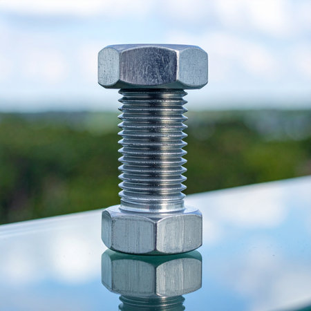 A single, gleaming stainless steel bolt and nut stand as a symbol of strength and precision engineering.の素材