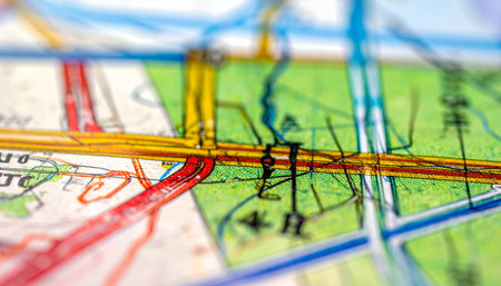 A close-up, selective focus view of a colorful city map highlights the intersection of roads and pathways.の素材