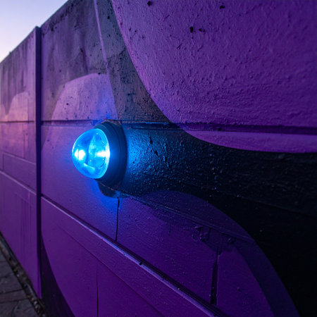 A single blue light glows with mysterious intensity against a vibrant purple wall, casting an eerie, futuristic ambiance.の素材