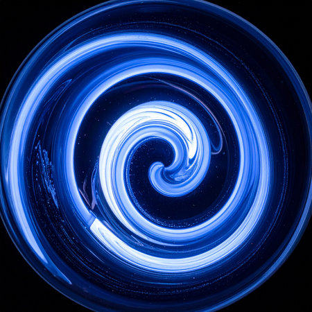 A mesmerizing vortex of brilliant blue light swirls into a hypnotic spiral against a deep black void.の素材