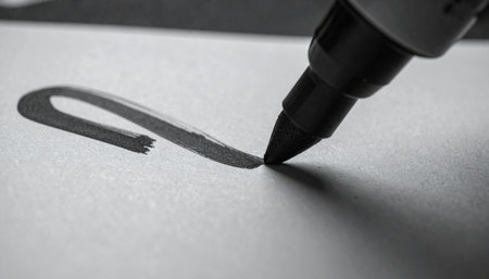 In a moment of focused creativity, the tip of a black marker glides across a clean white surface, laying down the first stroke of a new idea.の素材
