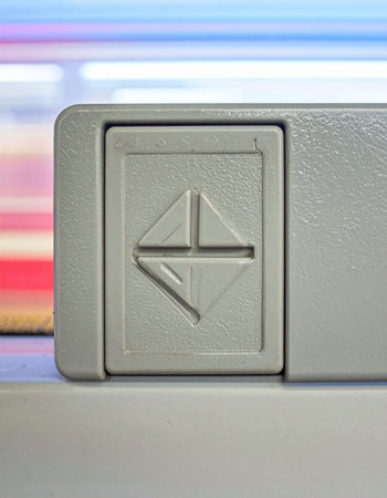 A macro view of a vintage eject button on a piece of classic hardware.の素材