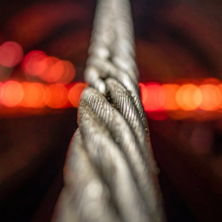 A powerful macro shot of a thick, twisted steel wire rope, its metallic texture in sharp focus.の素材