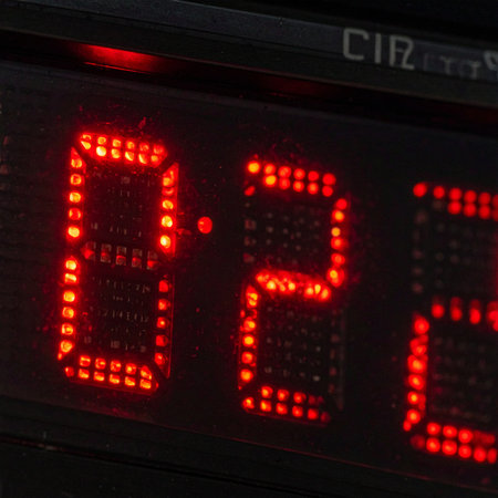 A macro shot of a glowing red digital display showing the number 0.2. The seconds tick away on a timer, creating a sense of urgency, a looming deadline, or the final moments of a competition.の素材