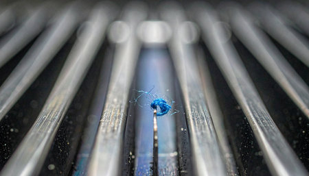 A single, vibrant blue droplet stands out in a stark, monochromatic world of parallel lines.の素材