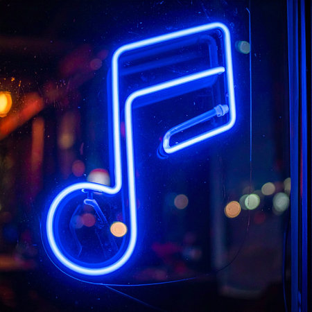 A vibrant blue neon musical note glows brightly in the dark, casting an electric hue against a window.の素材