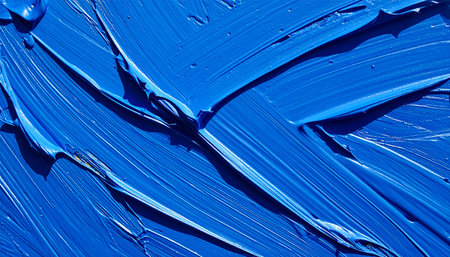 A close-up macro view captures the dynamic energy of thick, expressive blue oil paint.の素材