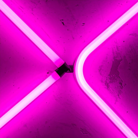 A close-up detail of a vibrant pink neon light creates a dynamic and energetic abstract background.の素材