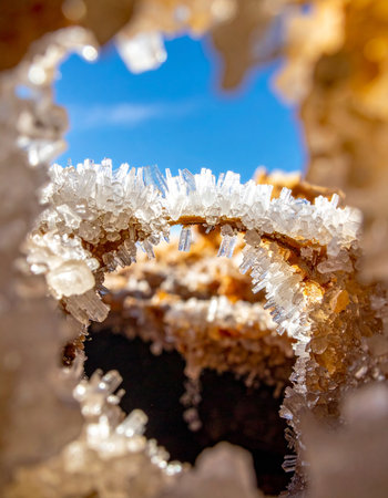 A macro perspective reveals delicate white salt crystals forming on a heavily corroded, rusty surface.の素材