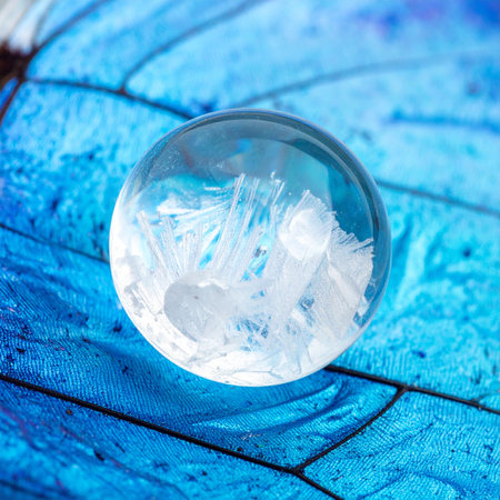 A perfectly clear crystal sphere holds a captured wisp of a cloud, frozen in time.の素材