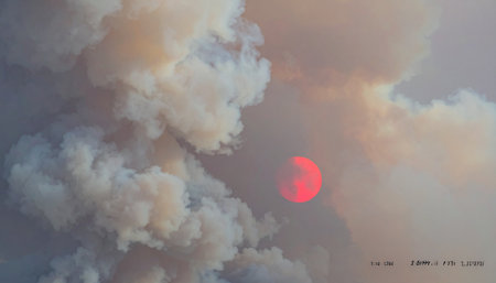 In a dreamlike landscape, a giant figure emerges from the swirling chaos of clouds, a silent witness to the dying red sun.の素材