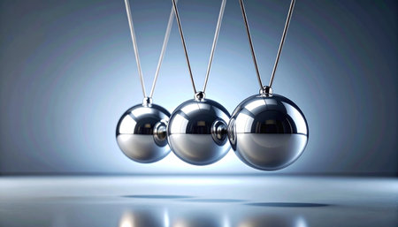 In a display of classic physics, the polished spheres of a Newton's cradle hang in perfect alignment, poised for impact.の素材