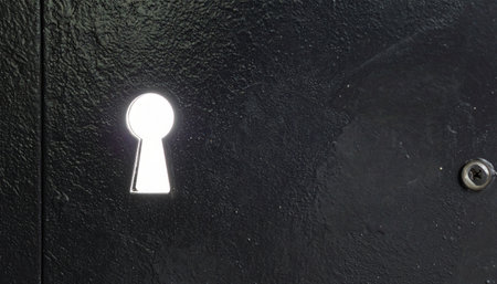 A single, illuminated keyhole stands out against a dark, textured background, symbolizing a hidden secret, a new opportunity, or a challenge waiting to be unlocked.の素材