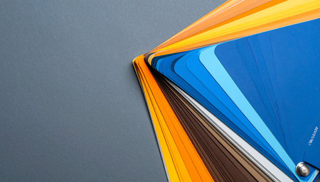A vibrant fan of color swatches unfolds against a neutral grey background, showcasing a spectrum from deep blues to warm oranges.の素材