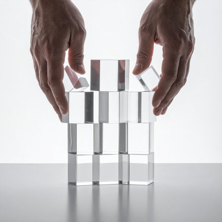 With careful precision, two hands place the final transparent block, completing a fragile yet stable structure.の素材