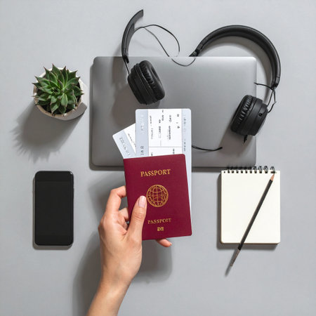 A traveler's hand holds a passport and tickets, ready for an international journey.の素材