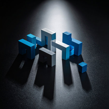 A single spotlight dramatically illuminates a cluster of abstract geometric blocks on a dark surface.の素材