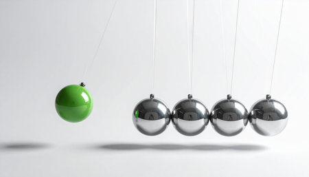 A single green sphere is about to strike a line of chrome balls, illustrating the powerful concept of a single action creating a significant chain reaction.の素材