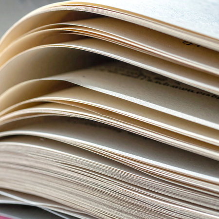 A close-up view reveals the gentle curve of aged pages, each one a layer of history and knowledge.の素材