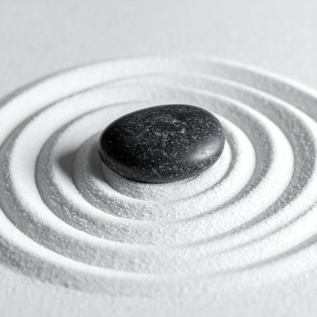 A single dark stone rests at the center of a tranquil Zen garden, its presence creating perfect, calming ripples in the fine white sand.の素材