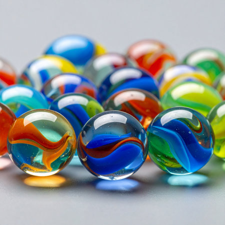 A close-up view of a vibrant pile of glass marbles, their colorful swirls catching the light.の素材