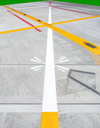 From a ground-level perspective, the intricate network of white, yellow, and red lines on the airport tarmac provides clear guidance.の素材