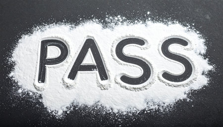 The word 'PASS' emerges from a field of white powder on a dark surface, symbolizing a successful outcome, achieving a goal, or passing a critical test.の素材