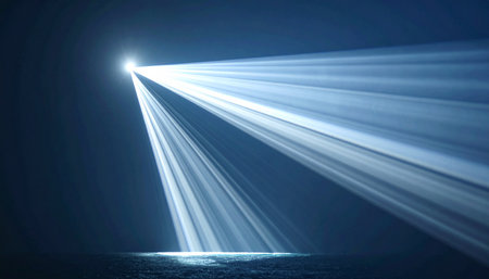 A single, powerful spotlight cuts through the darkness and atmospheric haze, illuminating an empty stage.の素材