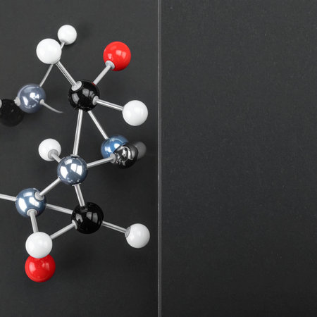 A detailed ball-and-stick model of a complex molecule against a dark, minimalist background.の素材