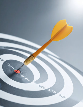 A single yellow dart strikes the dead center of the target, a powerful visual metaphor for achieving business goals with perfect accuracy and strategic focus.の素材