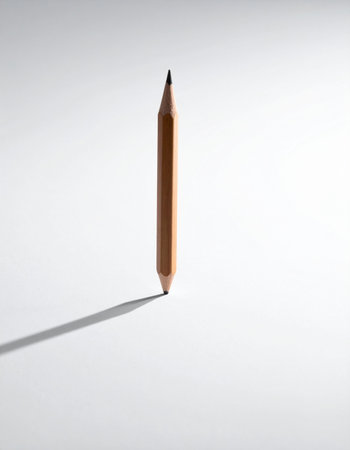 A single double-sided pencil defies gravity, perfectly balanced on its sharpened tip against a stark white background.の素材