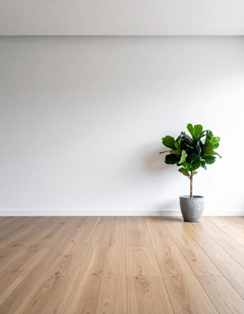 A single Fiddle Leaf Fig plant stands in a bright, empty room with warm wooden floors, symbolizing a fresh start, growth, and the potential of a new home.の素材