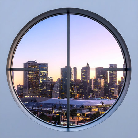 Gazing through a modern, circular window, the sprawling urban metropolis comes alive as the sun sets.の素材