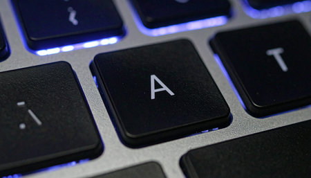 In the quiet glow of a modern workspace, a single key stands ready.の素材