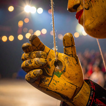 In the warm glow of the stage lights, a vintage wooden marionette awaits its cue.の素材