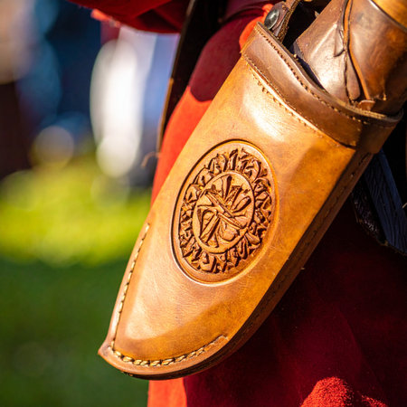 A close-up captures the intricate detail of a handcrafted leather knife sheath, worn as part of a historical costume.の素材