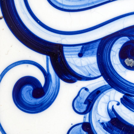 A close-up view reveals the fluid beauty of hand-painted cobalt blue swirls on a white ceramic surface.の素材