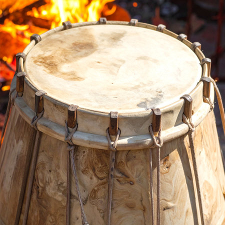 The deep, resonant heartbeat of an ancient drum calls to the spirit, its weathered skin glowing warmly in the flickering light of a sacred bonfire.の素材