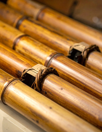 A detailed close-up captures the warm, golden tones of sturdy bamboo poles bound tightly with natural rope.の素材