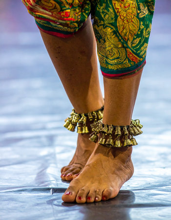A close-up captures the intricate details of a classical Indian dancer's feet, adorned with traditional ghungroo ankle bells.の素材