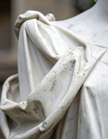 A close-up reveals the intricate folds of drapery on a classical marble statue.の素材