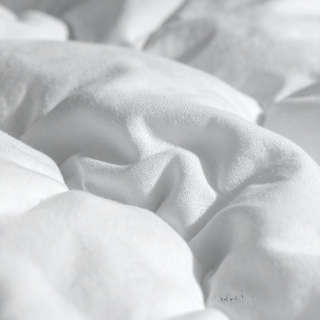 A close-up view captures the soft, inviting folds of a plush white comforter.の素材